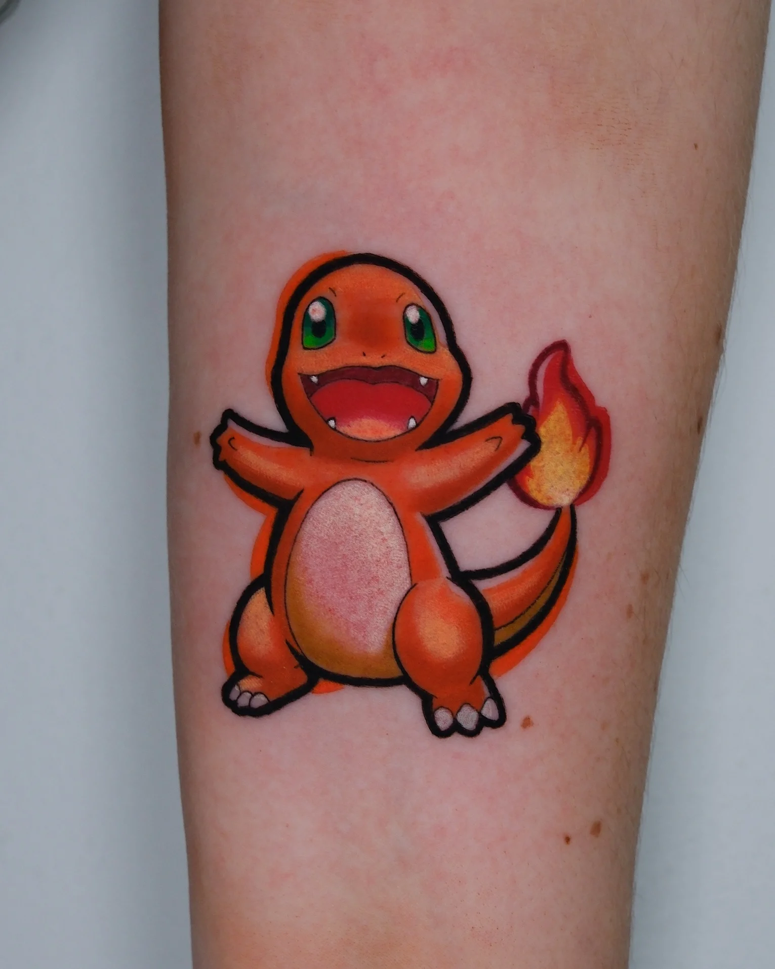 Colorful New School Charmander Pokemon tattoo on forearm