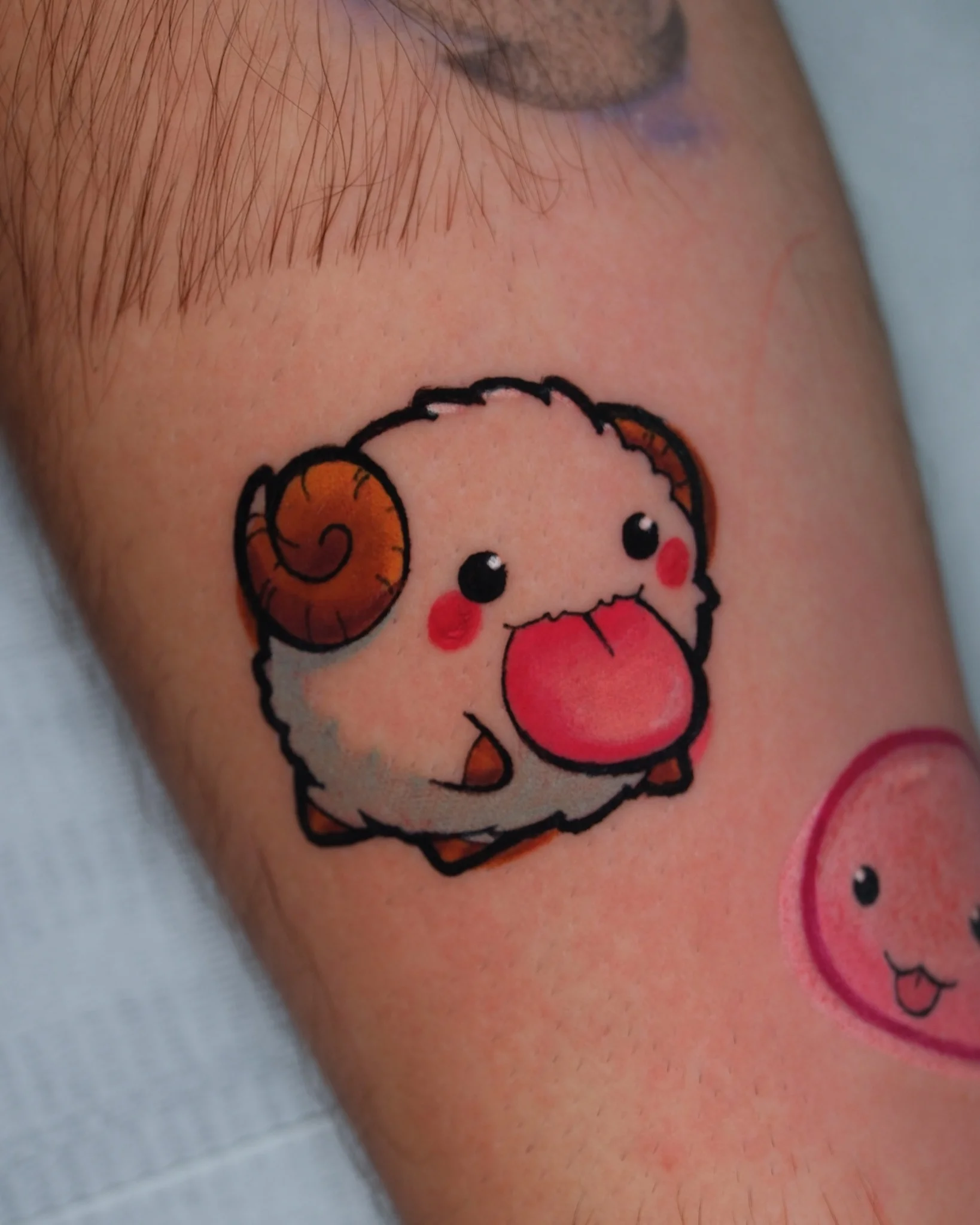 Colorful new school ram character tattoo on forearm with red accents