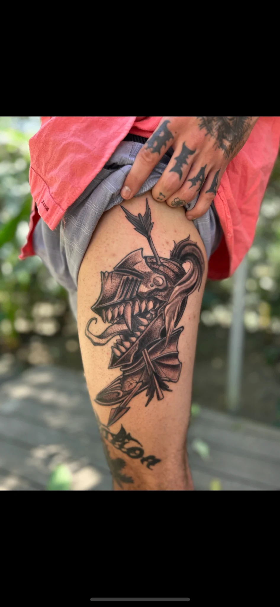 Black and grey demon head with arrow tattoo on thigh