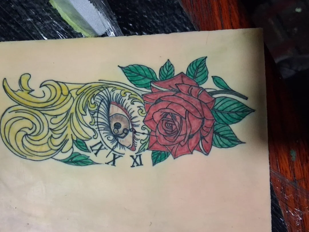 Color Rose with leaves and stem, eye with broken clock on synthetic skin.
