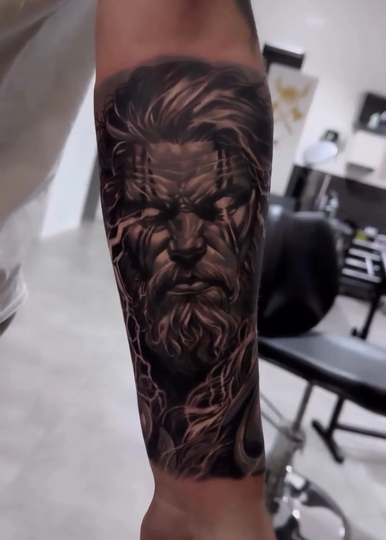 Black and grey realism Zeus portrait tattoo on forearm