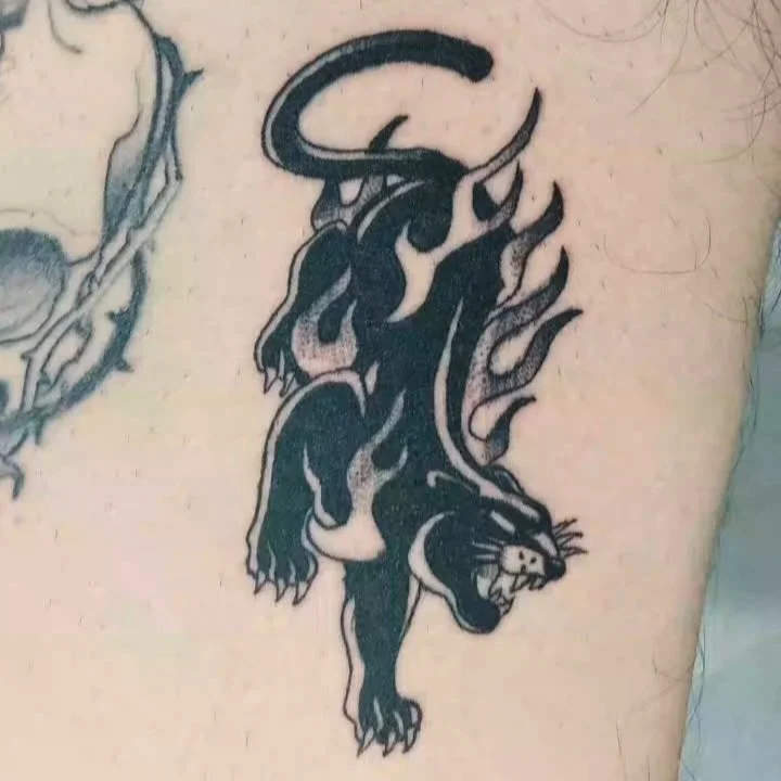Black American Traditional flaming panther tattoo on arm