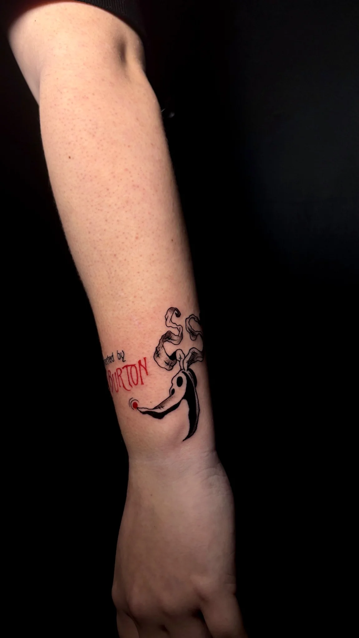 Illustrative Tim Burton inspired ghost figure tattoo on forearm