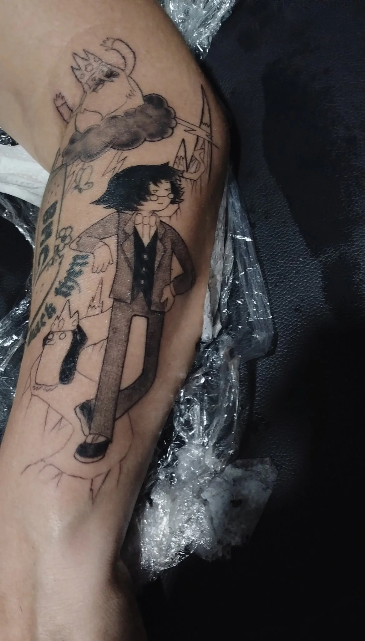 Illustrative black and grey character scene tattoo on forearm
