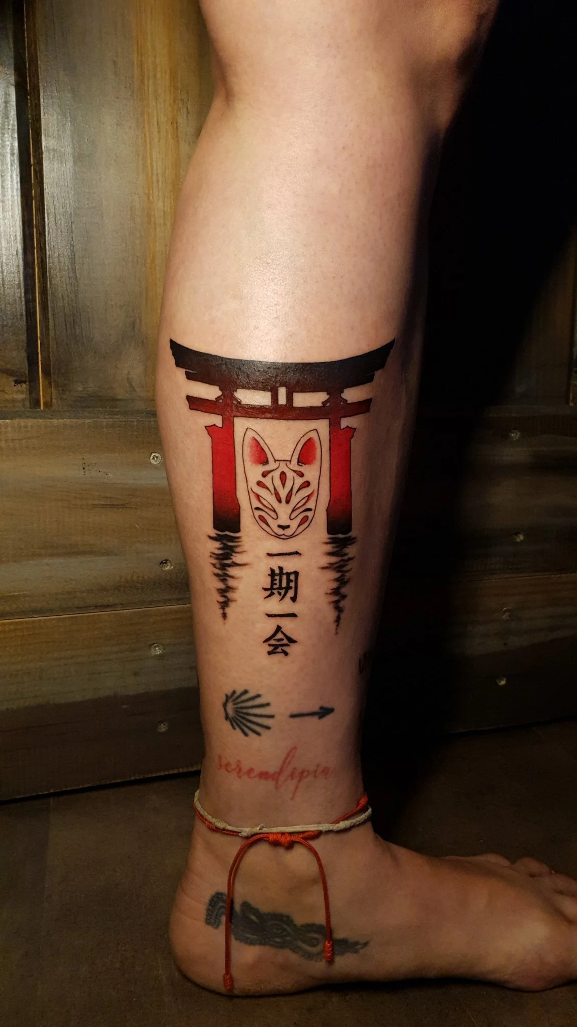 Japanese torii gate and kitsune mask tattoo with kanji on calf