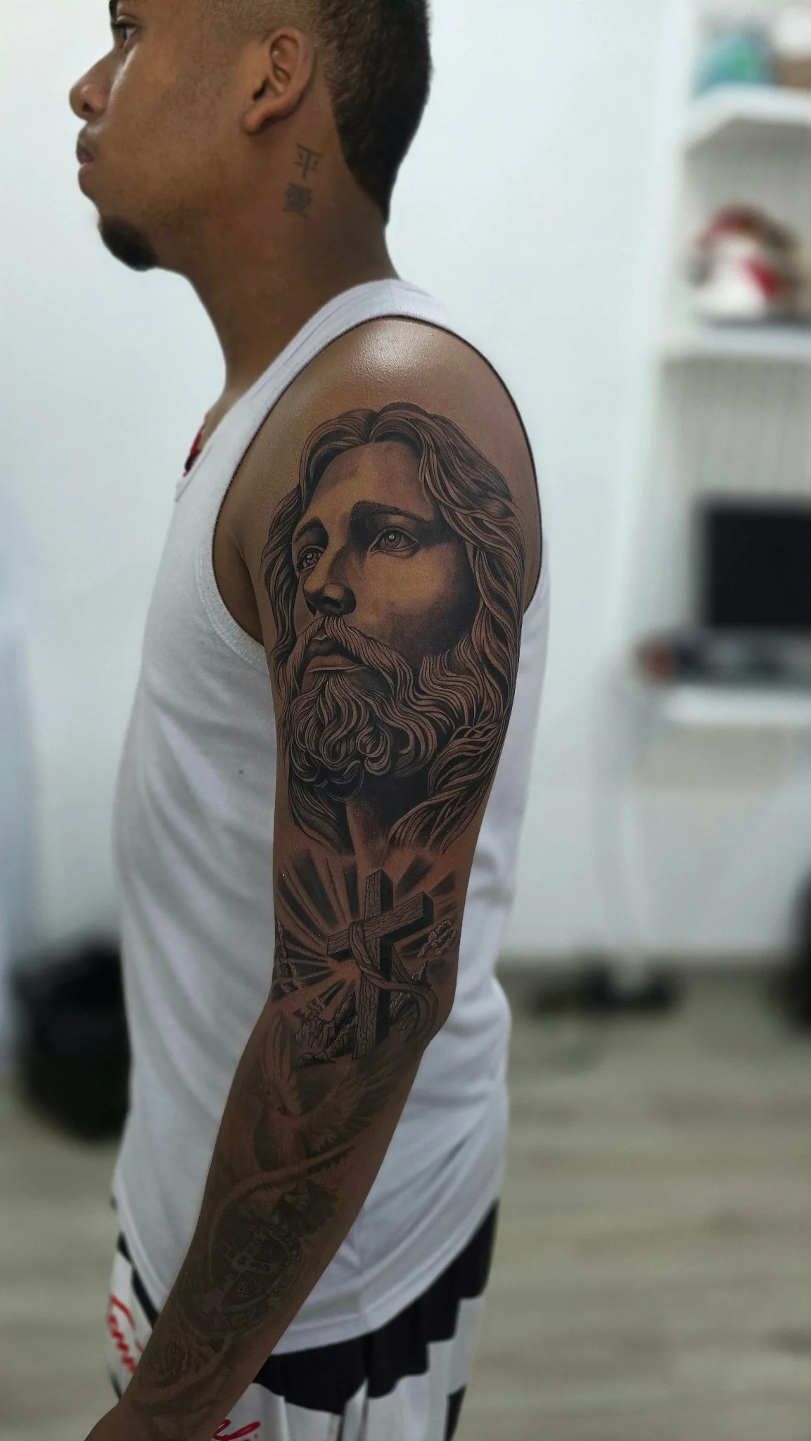 Black and grey realism Jesus Christ sleeve tattoo with cross