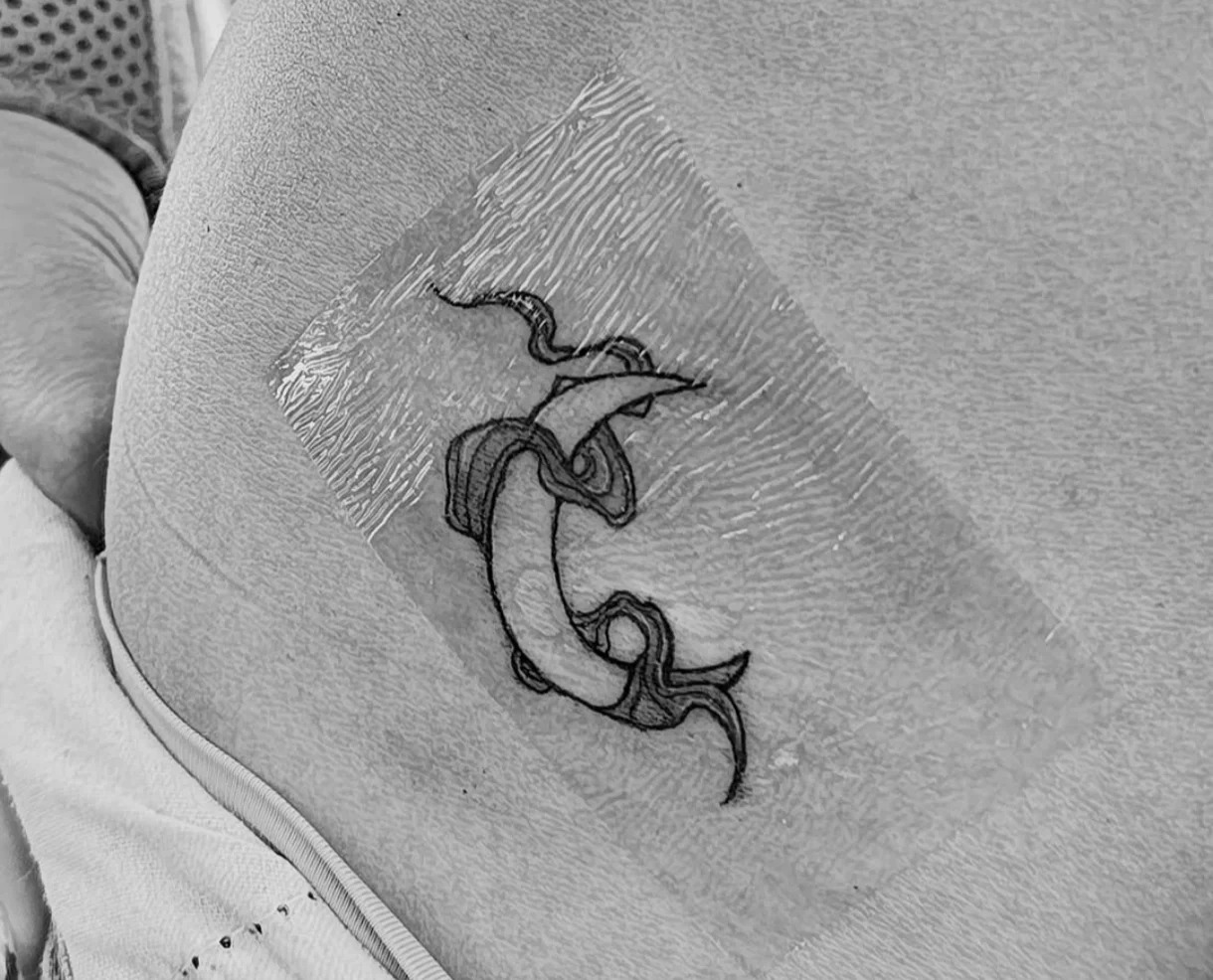 Neo-traditional koi fish tattoo on hip, freshly wrapped