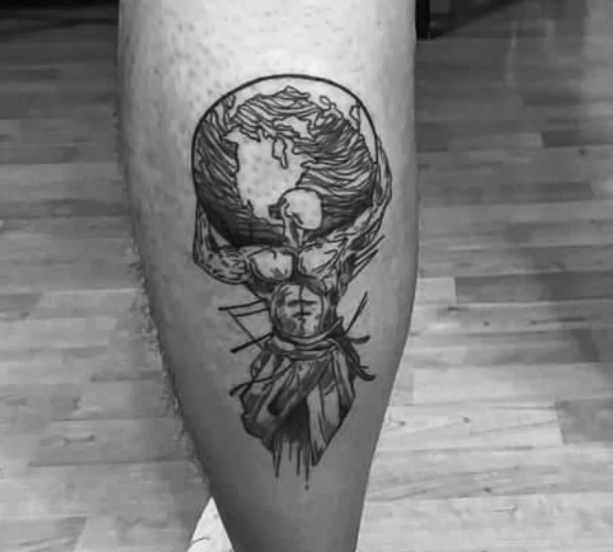 Sketch style Atlas holding the world tattoo on calf