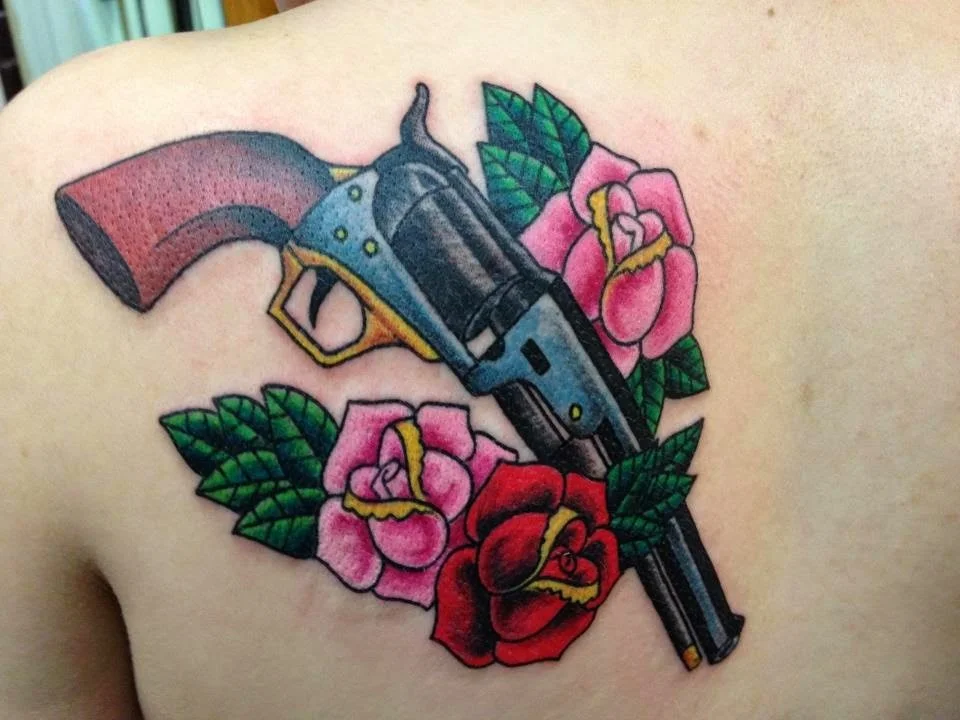 American traditional revolver and roses tattoo on upper back