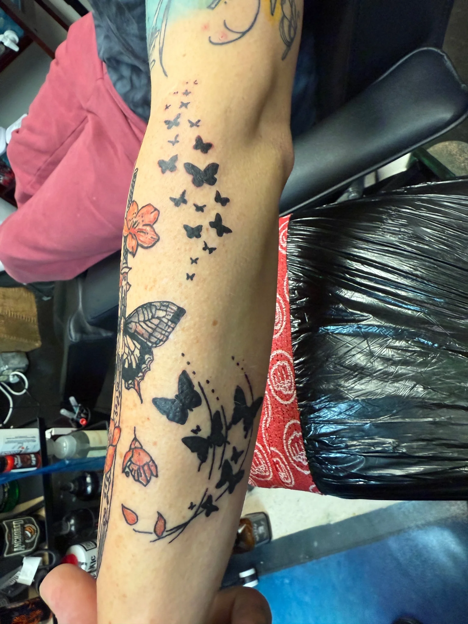 Black and color butterfly floral sleeve tattoo on forearm
