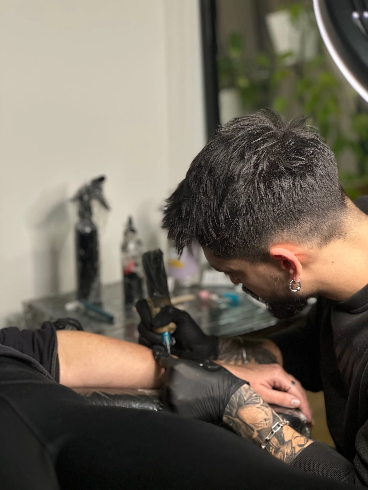 Black and grey floral tattoo being applied to forearm sleeve