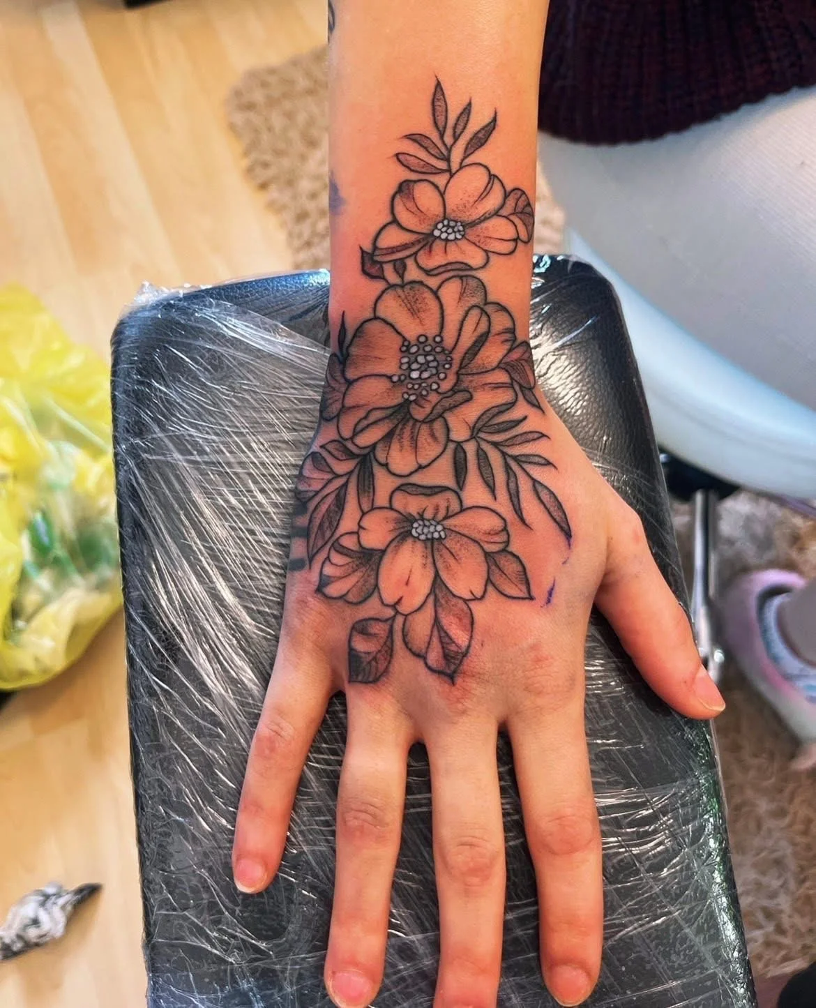 Neo-traditional floral tattoo covering hand and wrist