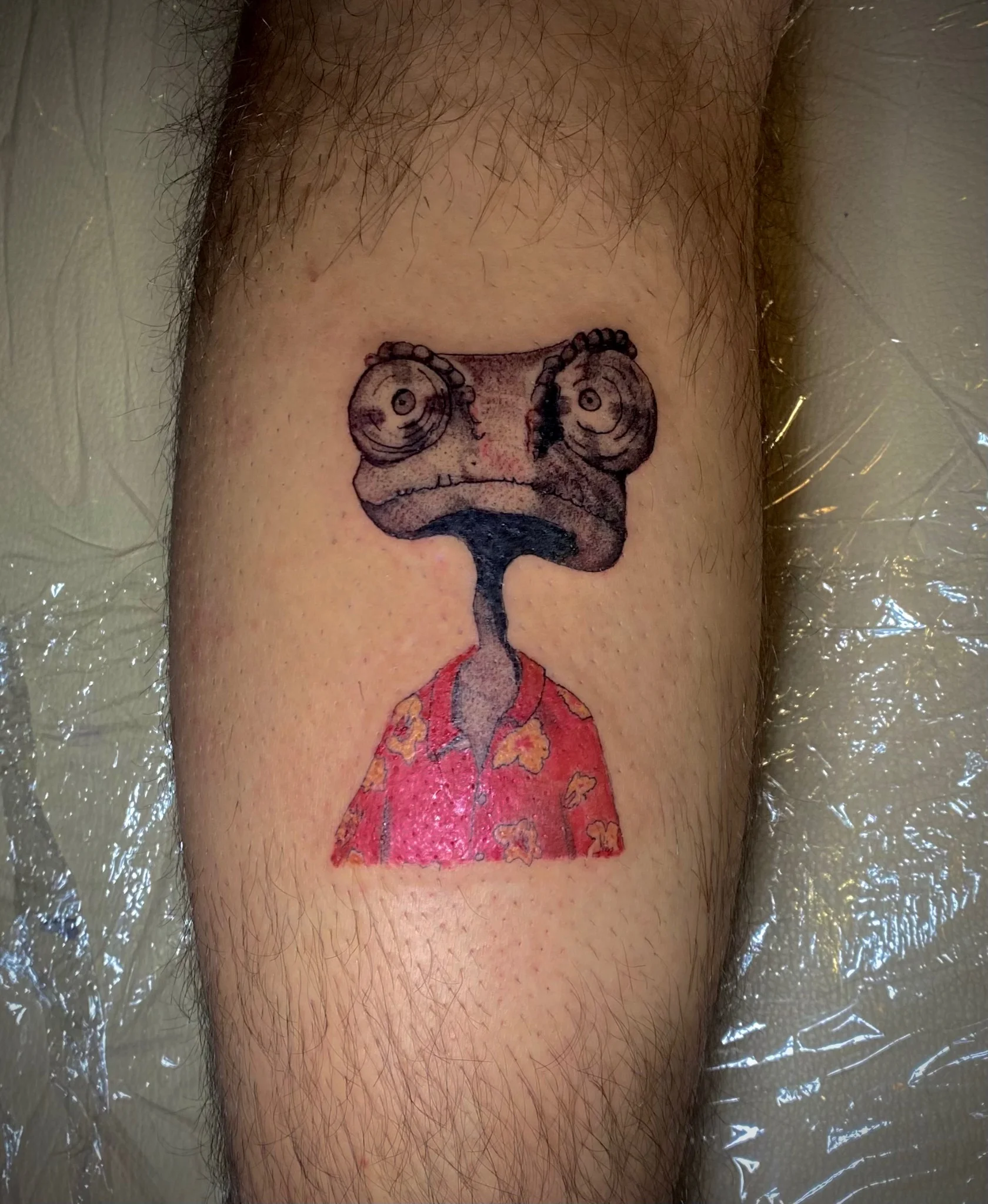 New School chameleon character in Hawaiian shirt tattoo on leg