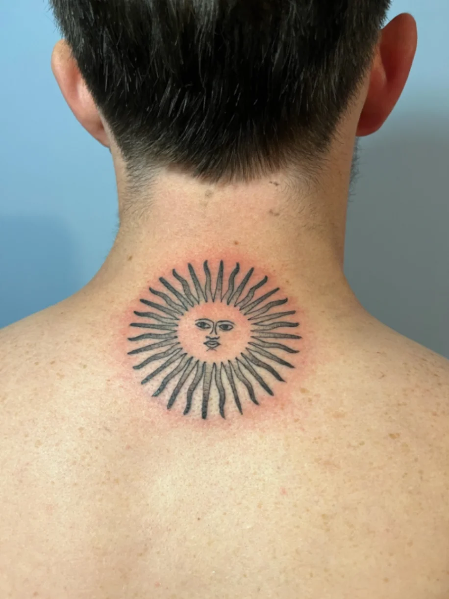 Fine line sun face tattoo on the back of the neck