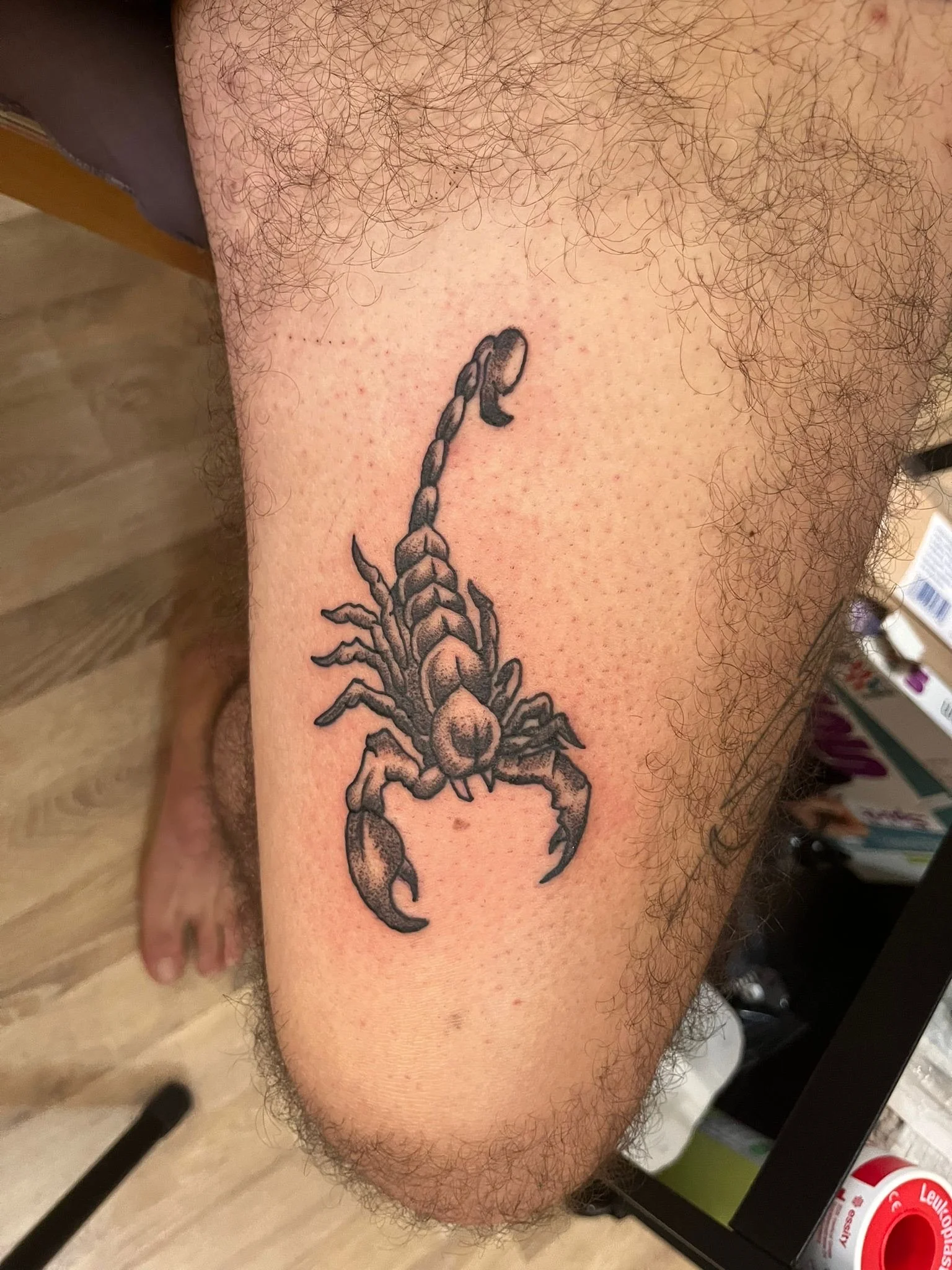 Black and grey scorpion tattoo on lower leg