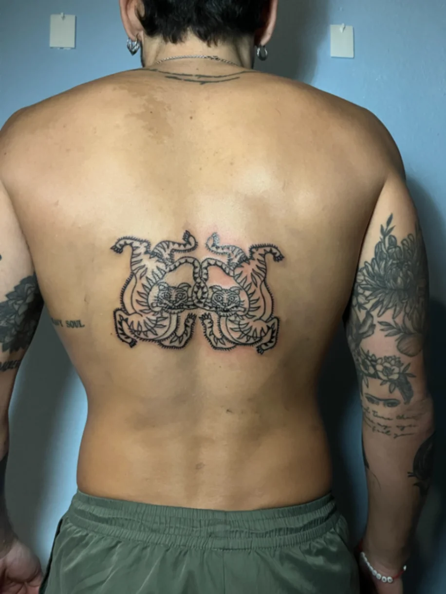 Mirrored double tiger neo-traditional tattoo on lower back