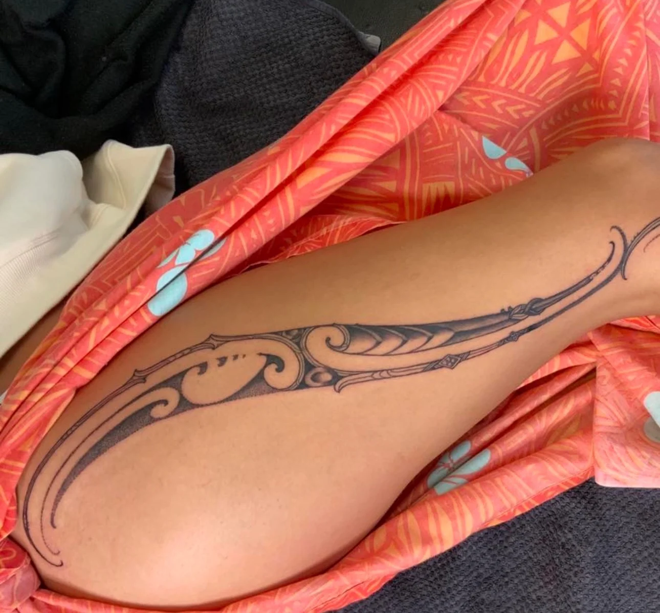 Polynesian tribal scroll tattoo on upper thigh and leg
