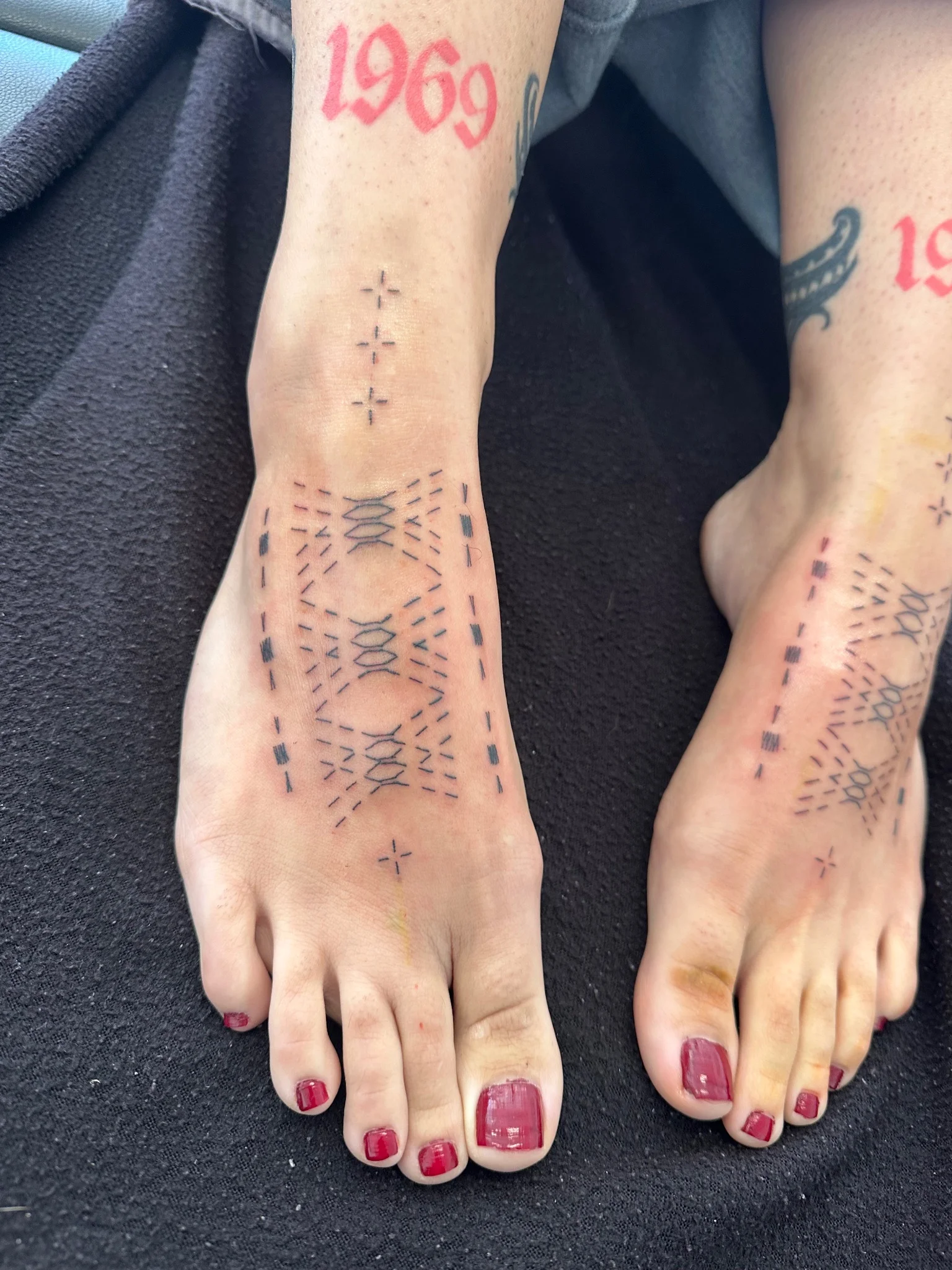 Matching geometric patterned handpoke tattoos on both feet