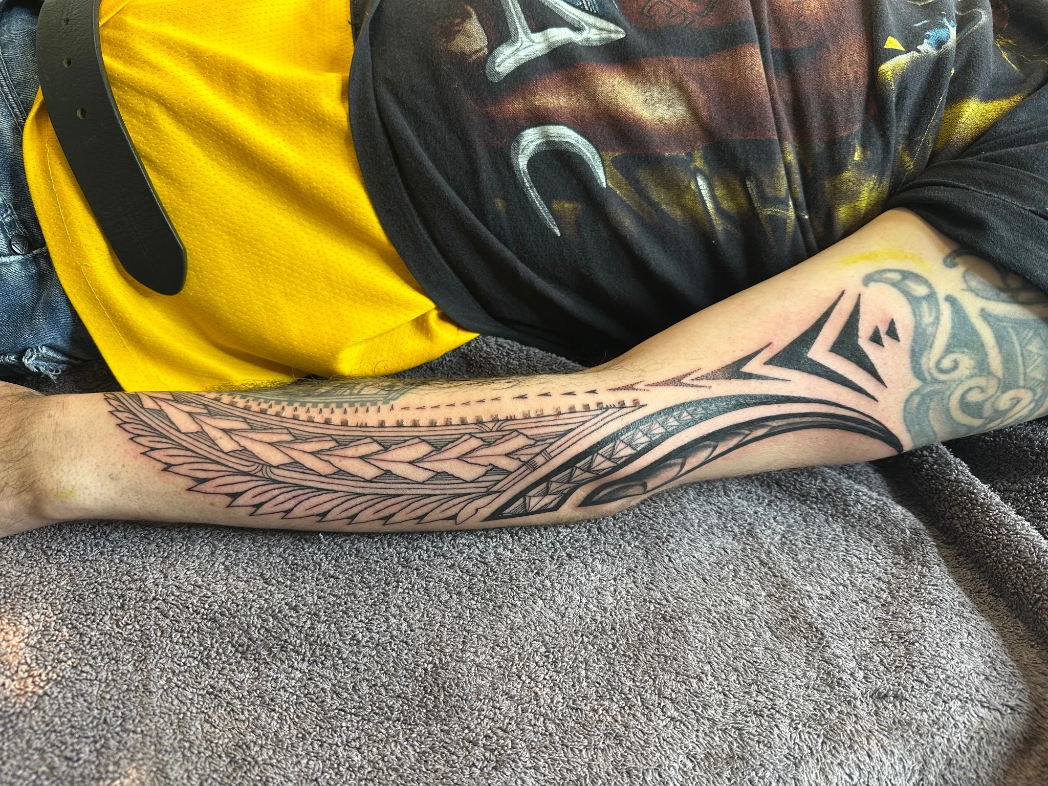 Polynesian tribal sleeve tattoo with geometric and leaf motifs on forearm