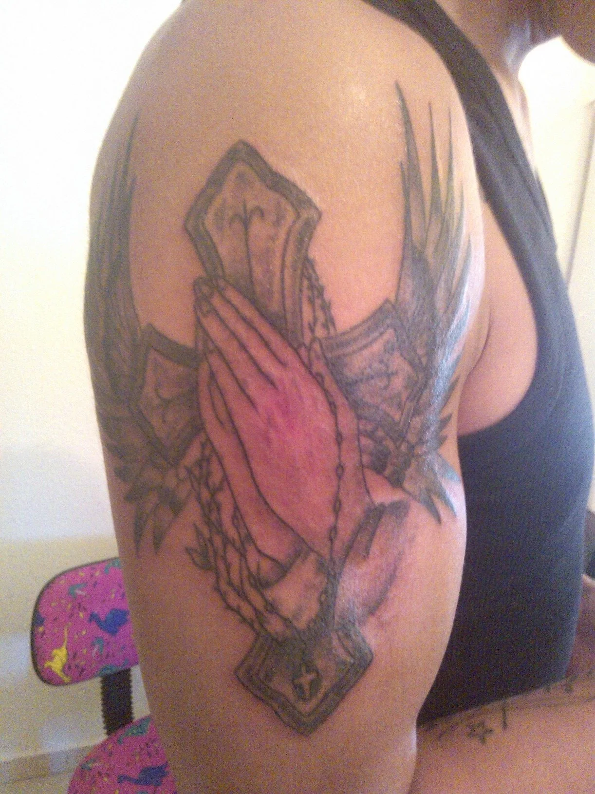 Neo-traditional praying hands cross with wings tattoo on upper arm