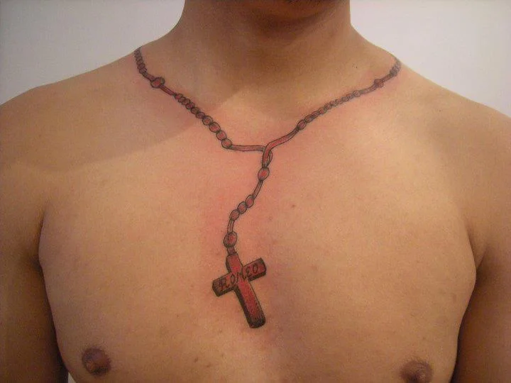 Red and brown rosary beads and cross tattoo on chest