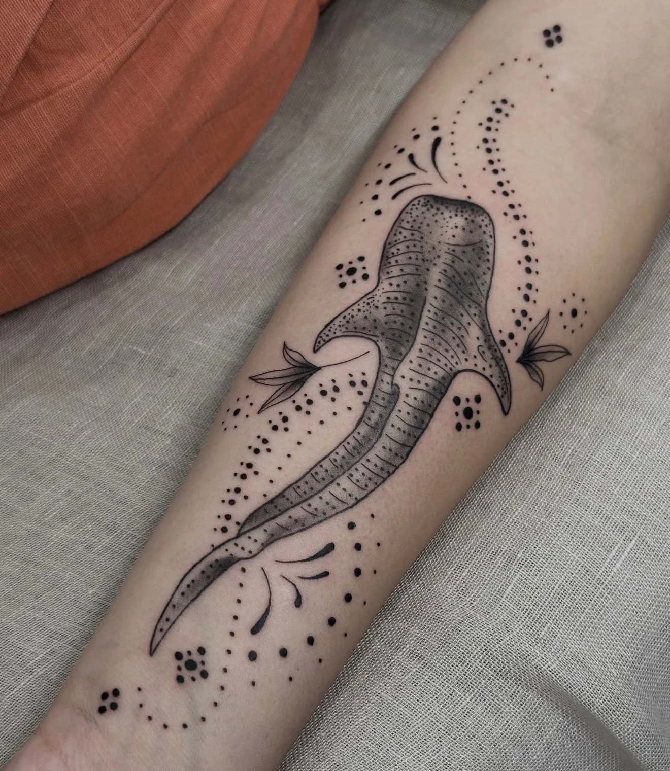 Dotwork whale shark tattoo with botanical accents on forearm