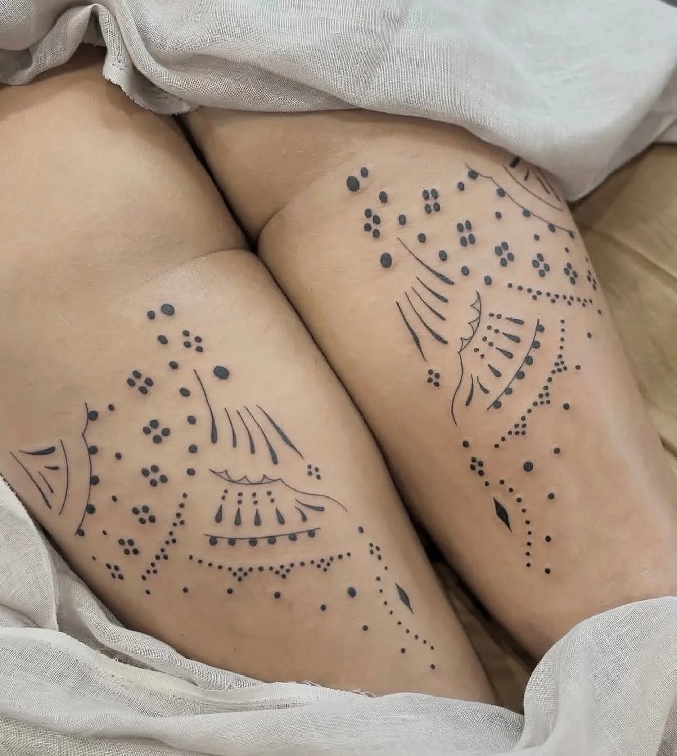 Dotwork ornamental pattern tattoos on both thighs