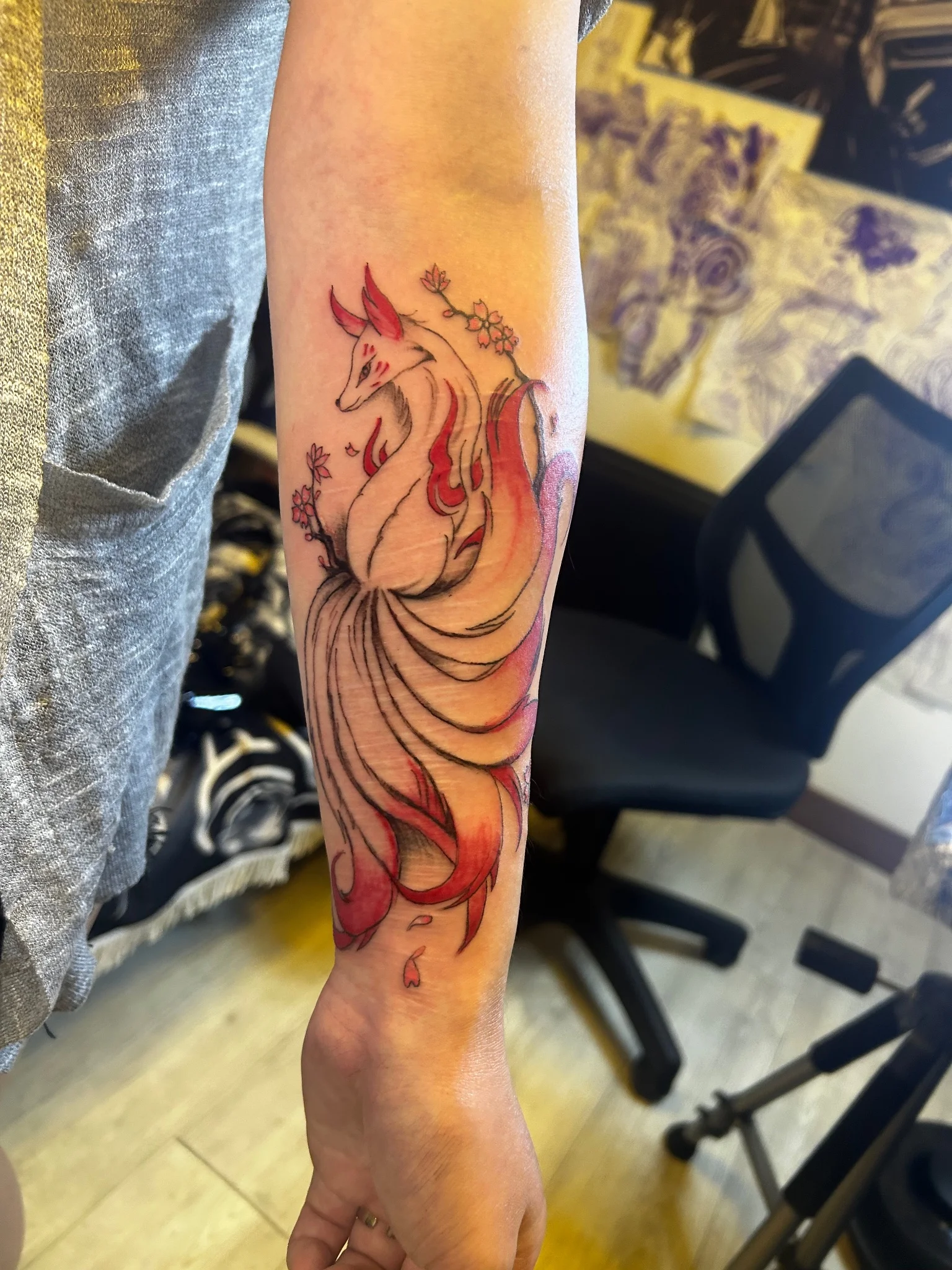 Neo-traditional kitsune fox with cherry blossoms tattooed on forearm
