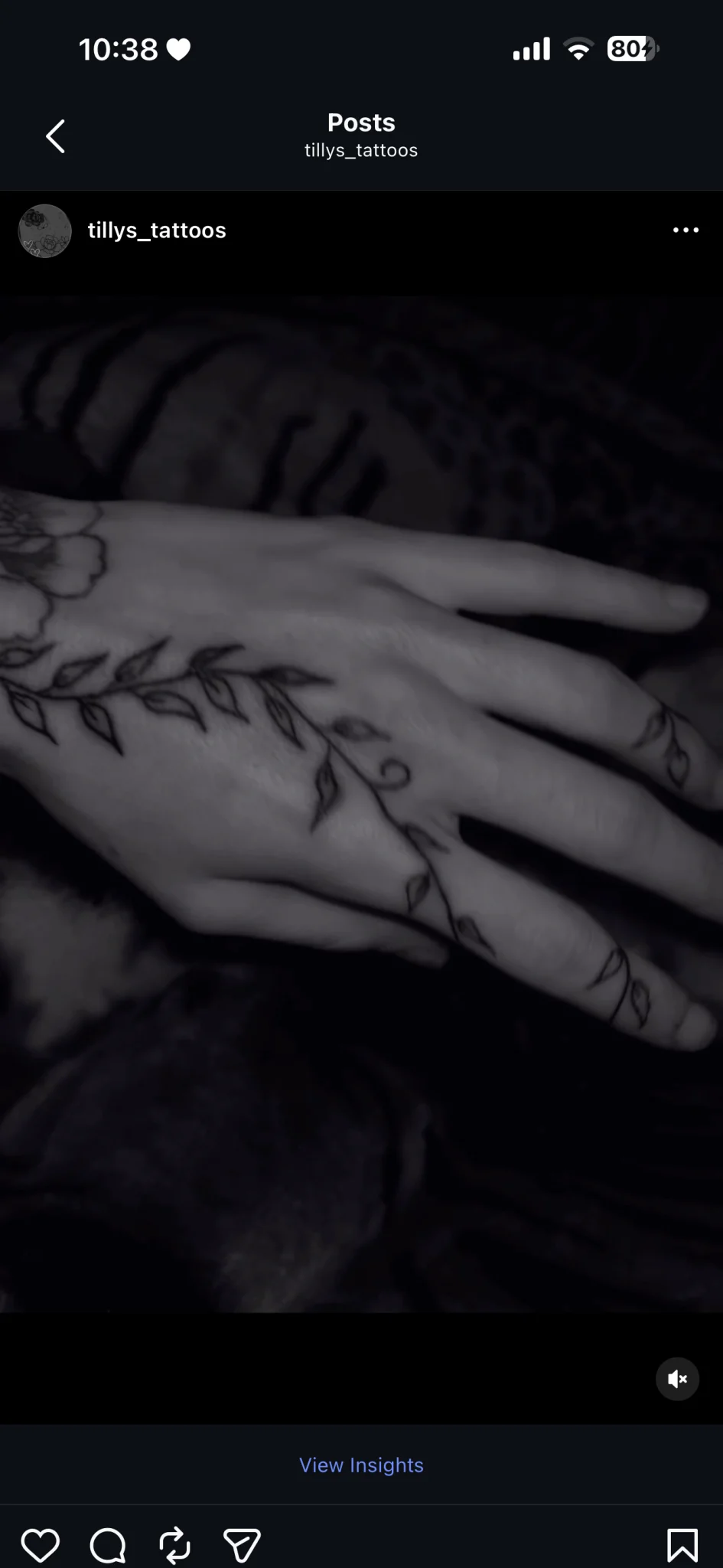 Fine line botanical vine tattoo across hand and fingers