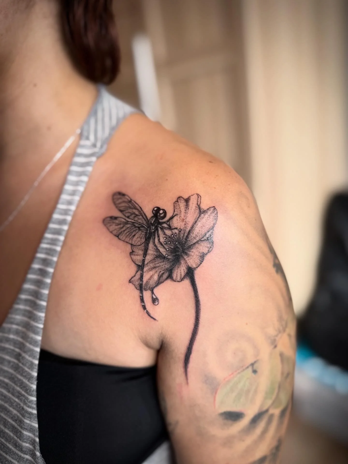 Fine line dragonfly and poppy flower tattoo on shoulder