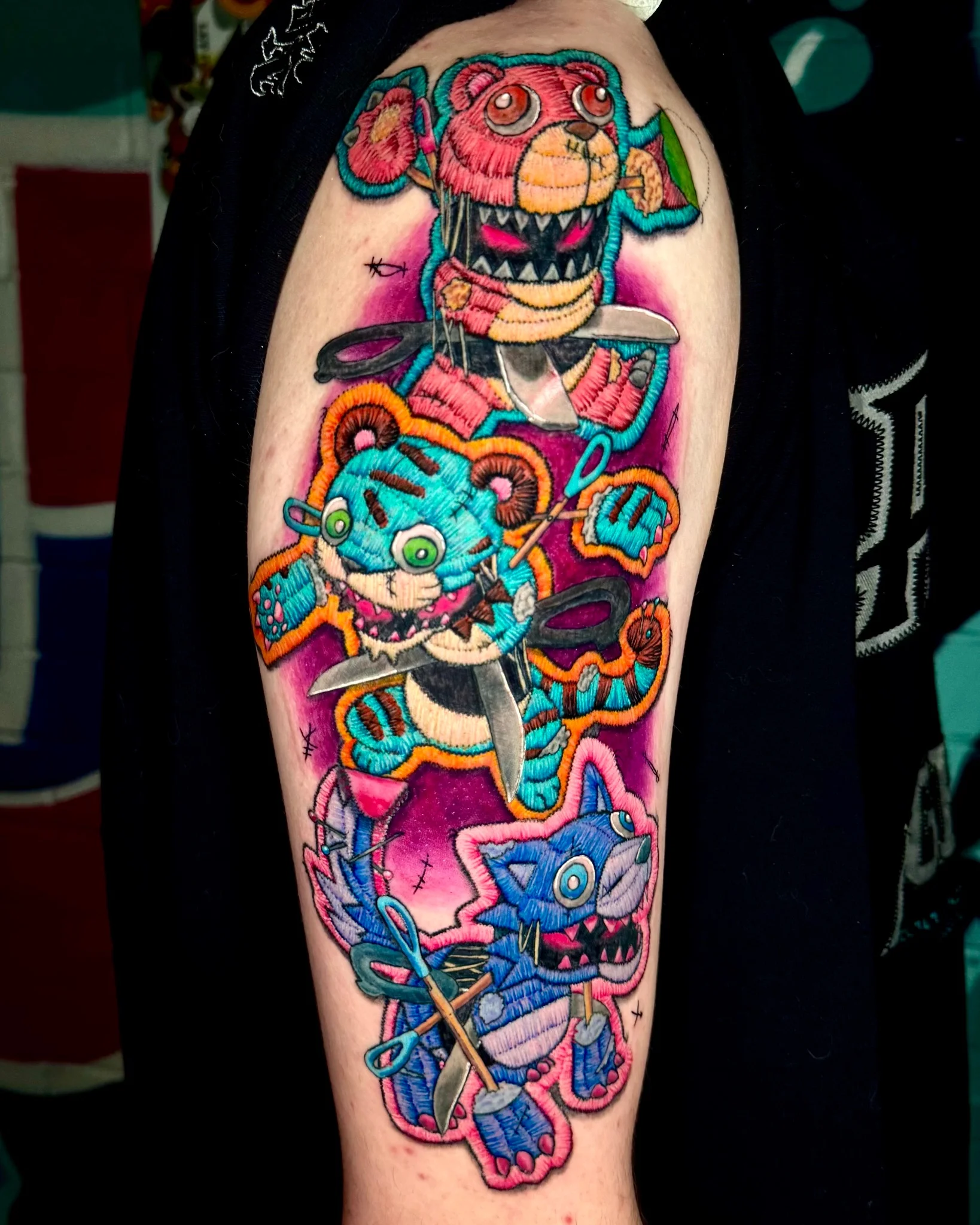 Colorful embroidery-style voodoo teddy bear tattoo on upper arm