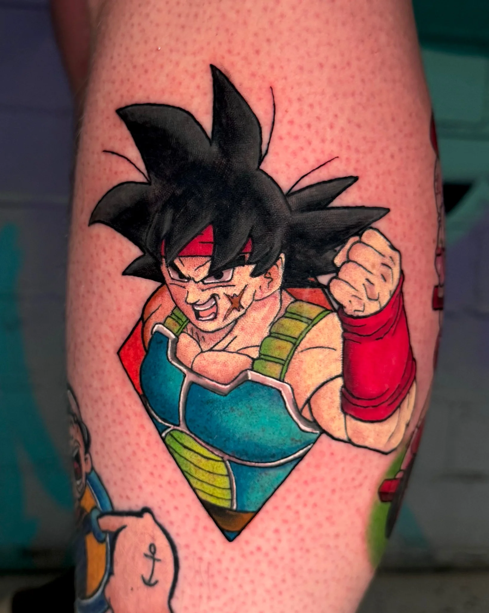 Colorful Bardock Dragon Ball anime tattoo on lower leg