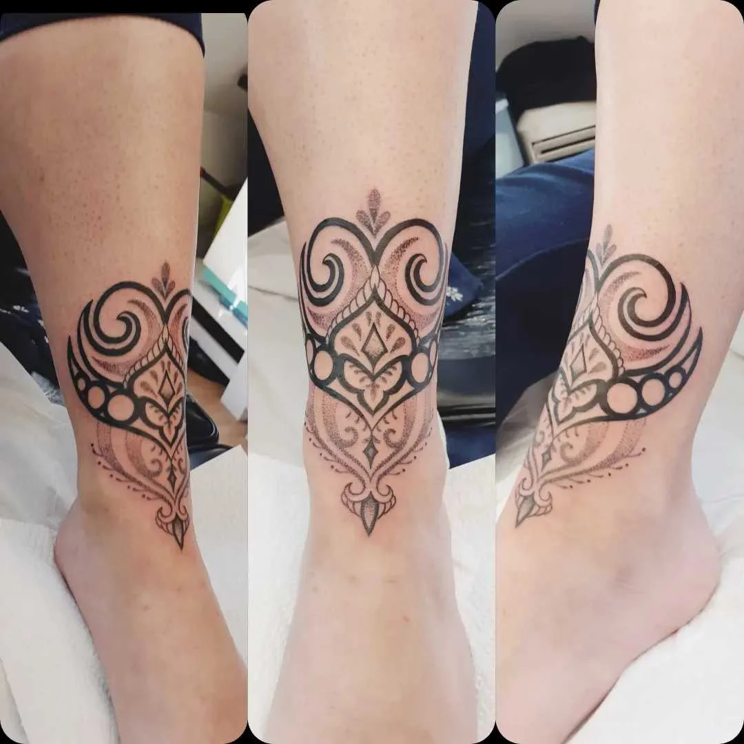 Ornamental wrap-around ankle tattoo with tribal and mandala elements