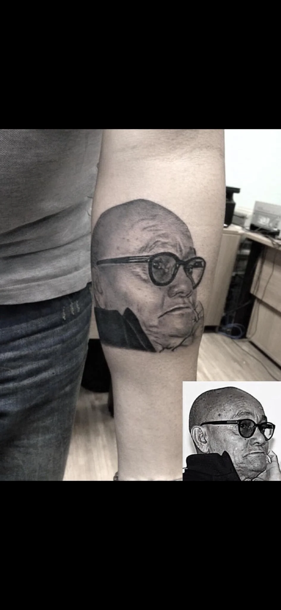 Black and grey realism portrait of an elderly man on forearm