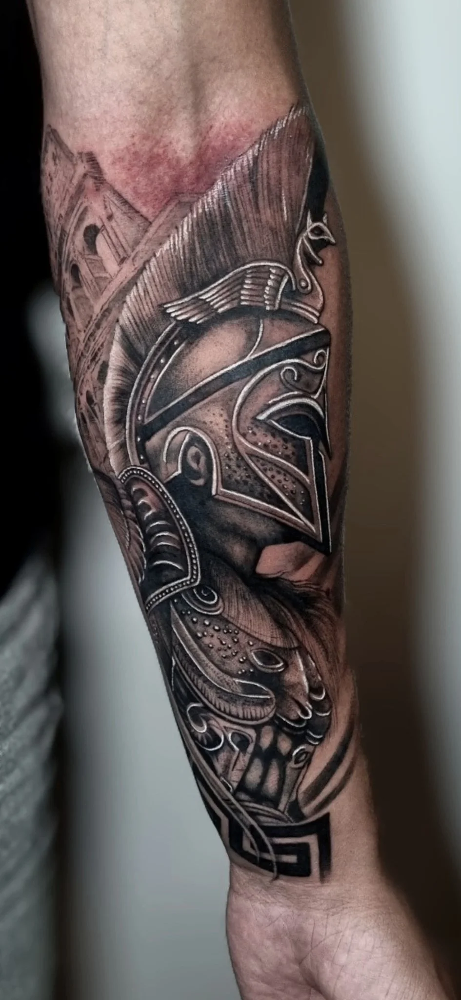 Black and grey realism Spartan helmet and shield tattoo on forearm