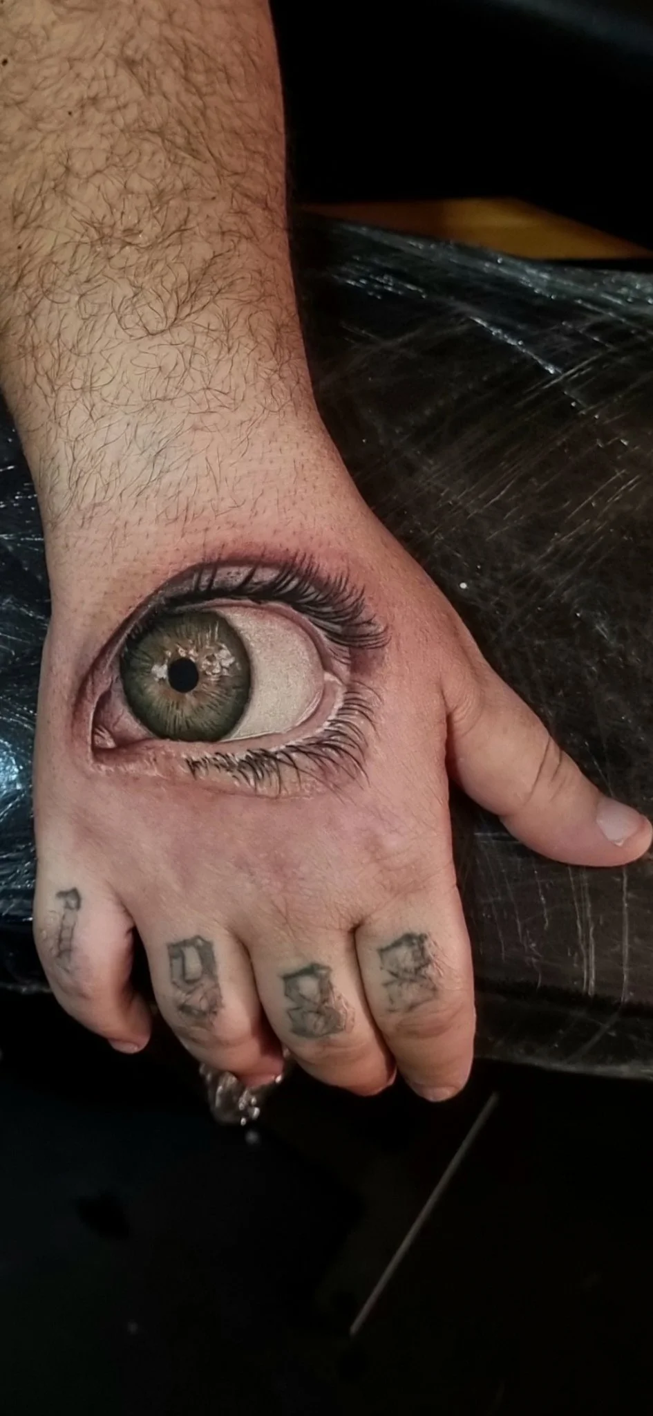Hyper-realistic eye tattoo on the back of the hand
