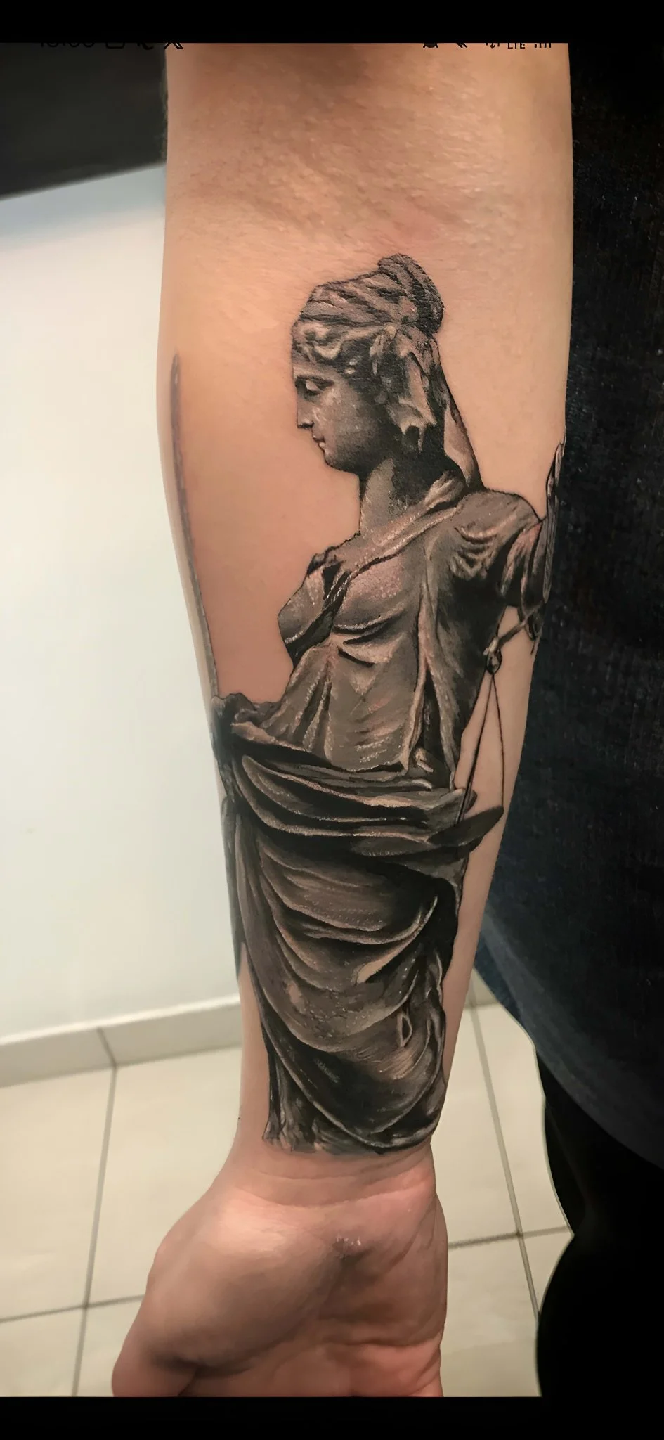 Black and grey realism Lady Justice statue tattoo on forearm