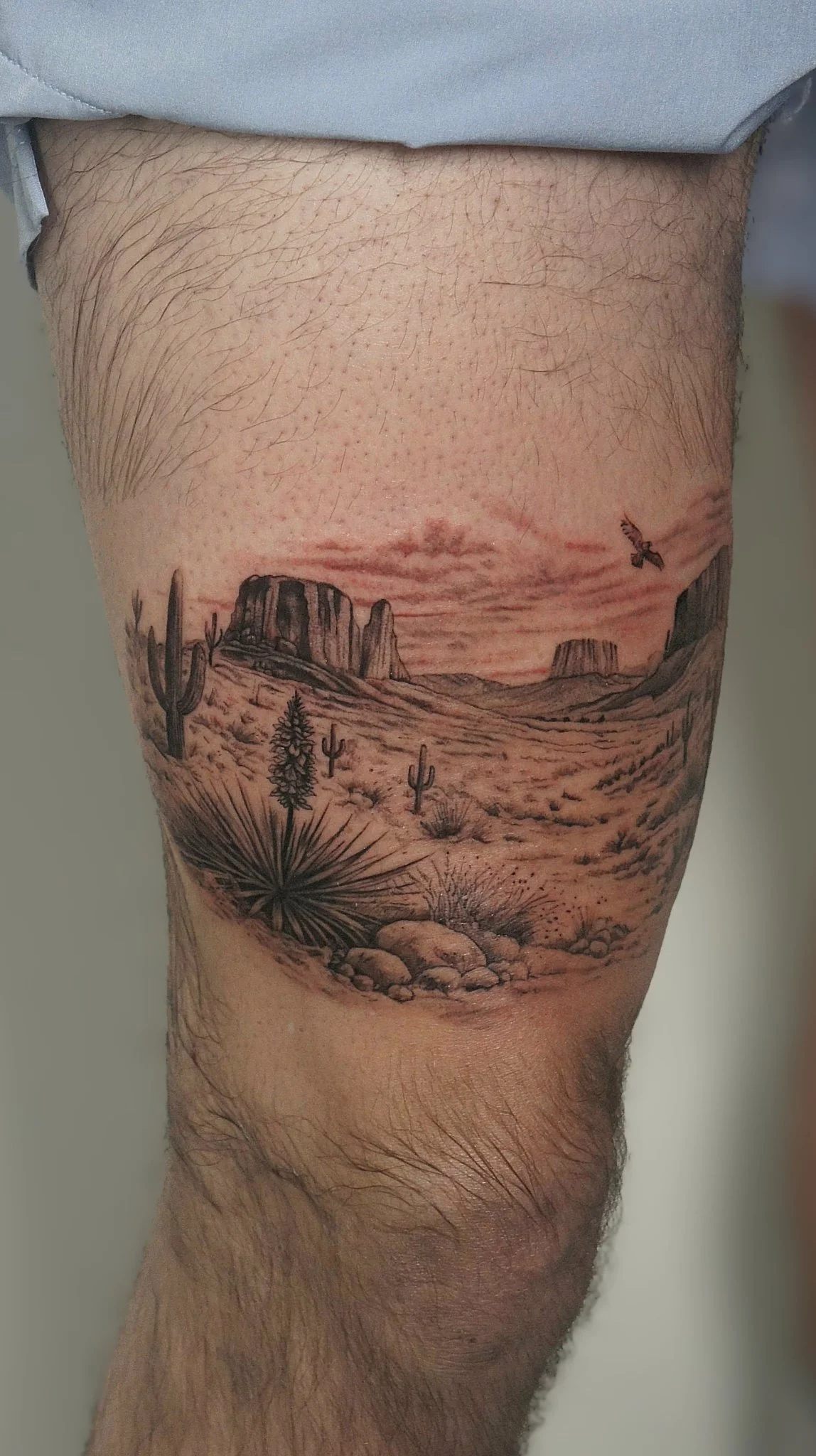 Black and grey realism desert landscape tattoo on knee