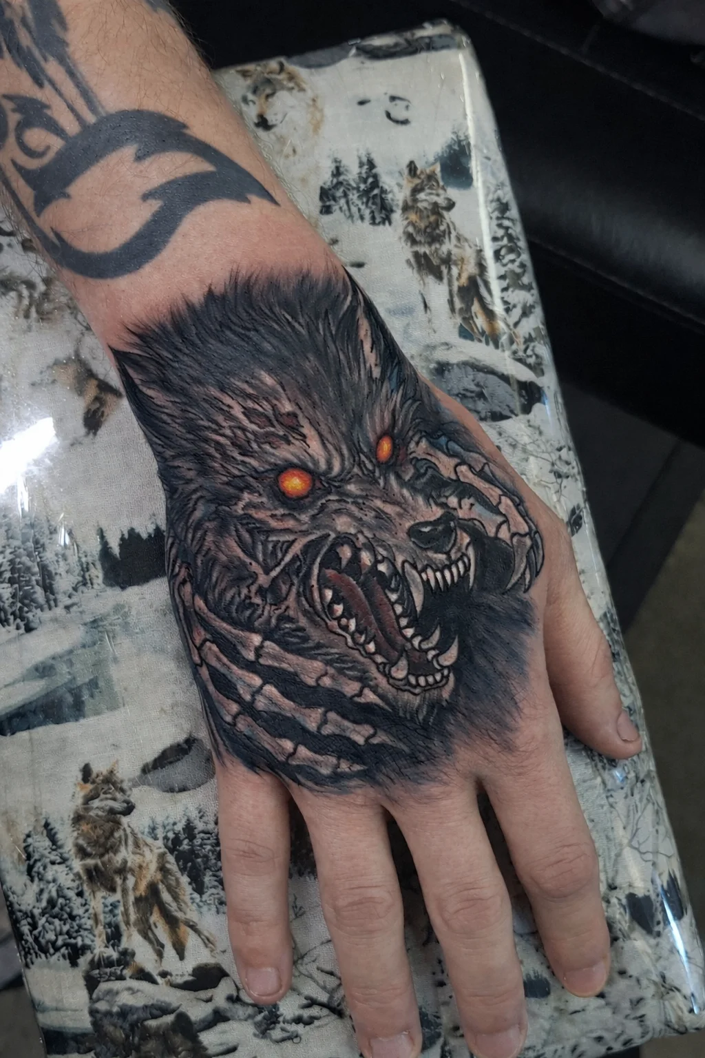 Horror style zombie wolf with skeleton hand tattoo on hand