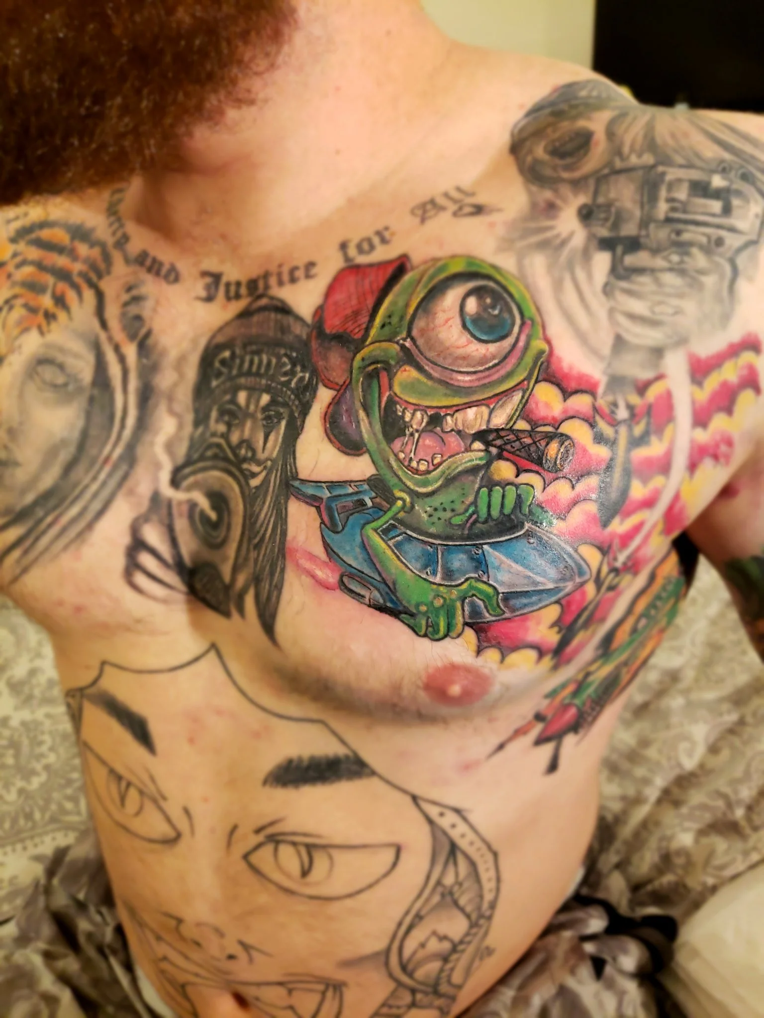 Colorful new school monster chest tattoo with lettering and portraits