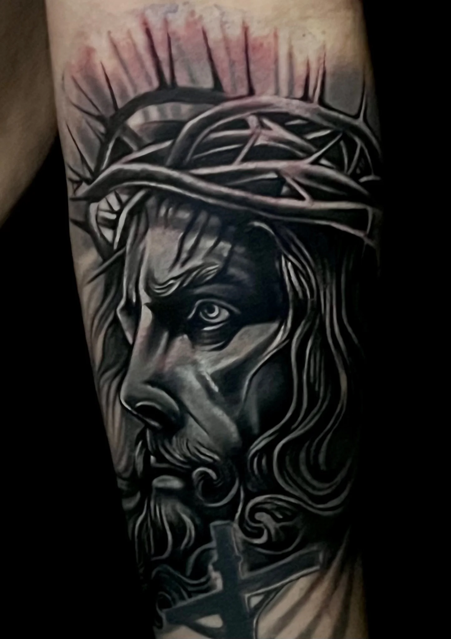 Black and grey realism Jesus portrait with crown of thorns on forearm