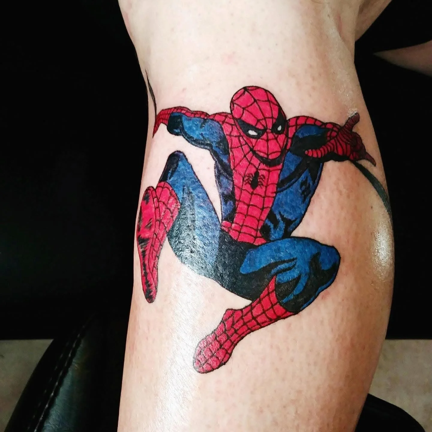 Colorful Spider-Man comic-style tattoo on lower leg