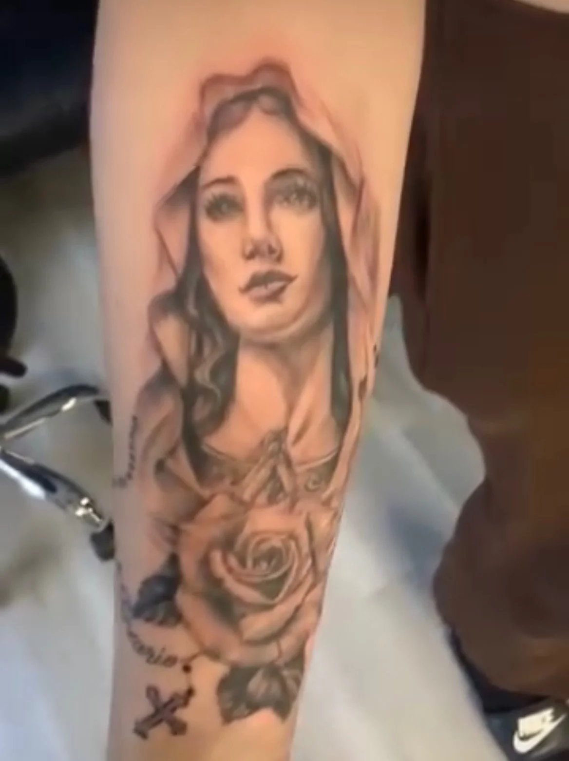 Black and grey Virgin Mary with rose and rosary on forearm