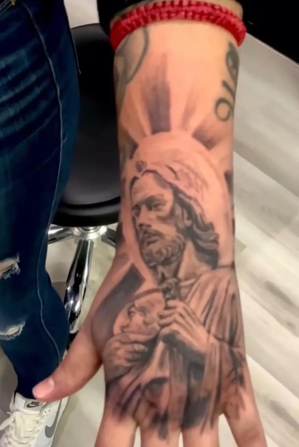 Black and grey realism religious figure tattoo on hand and forearm