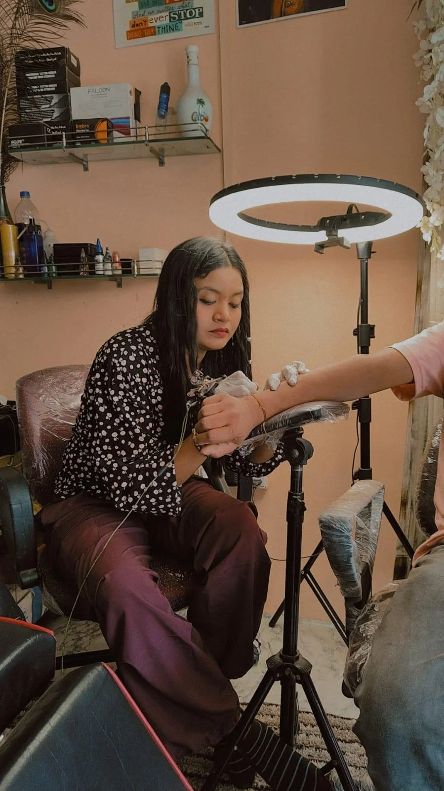 Tattoo artist working on a forearm tattoo in studio