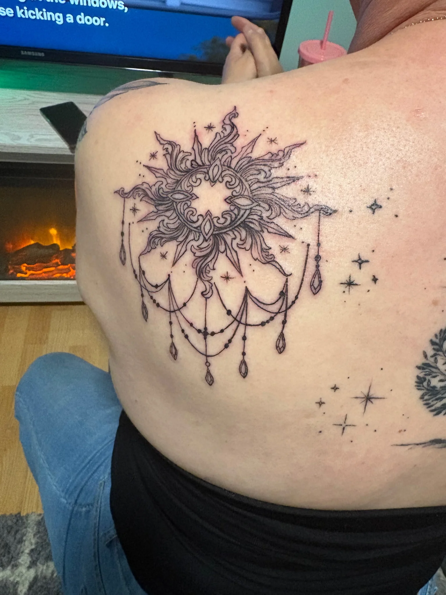 Fine line celestial sun with chandelier details on upper back