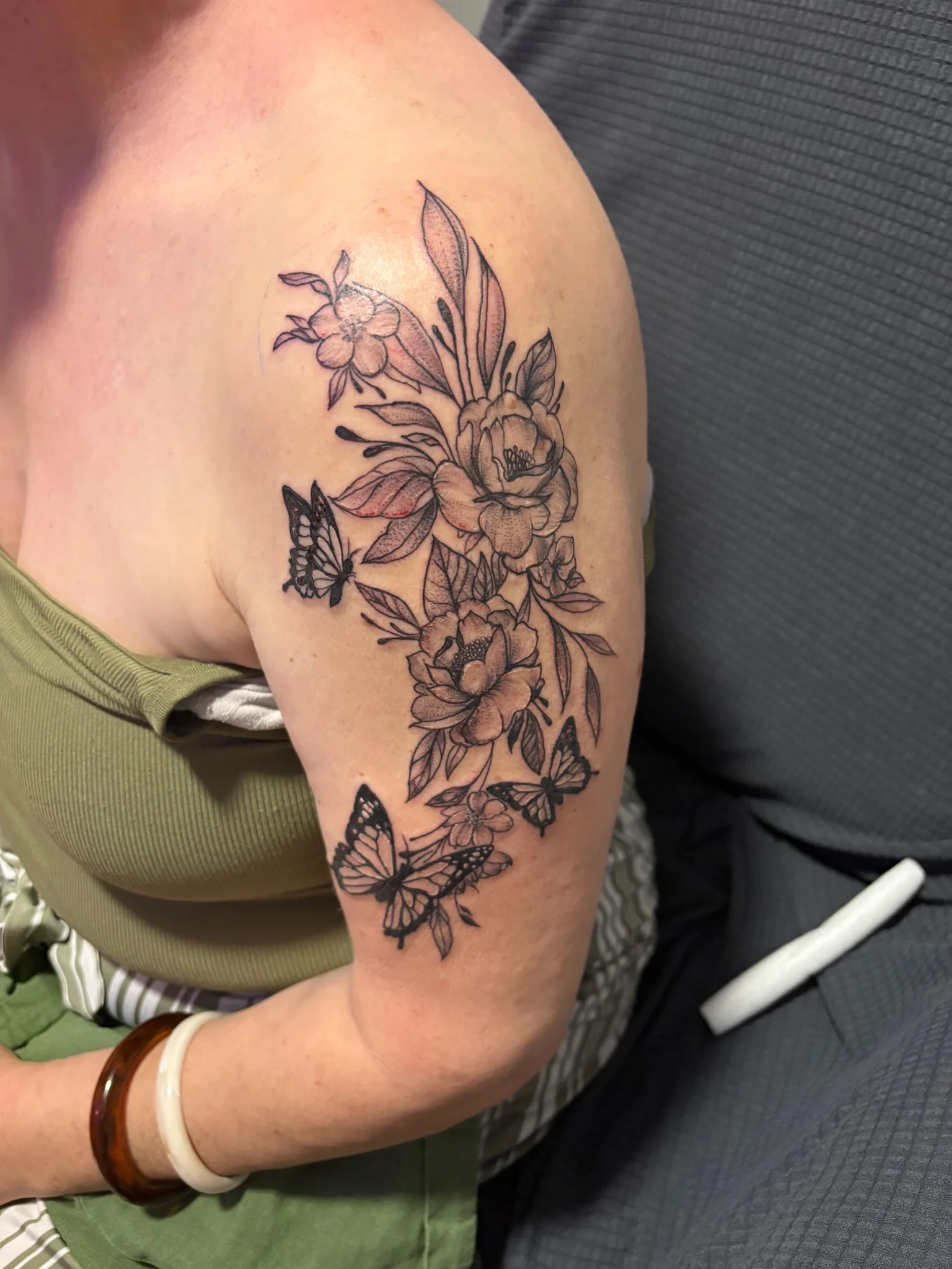 Fine line floral and butterfly composition on upper arm