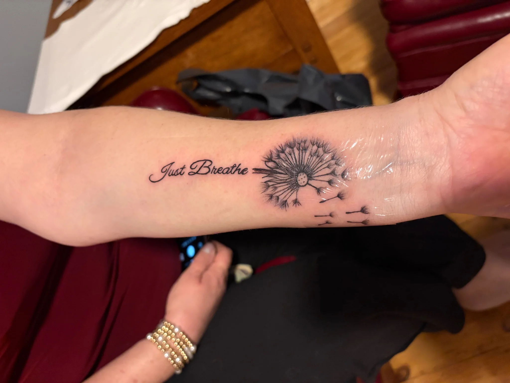 Fine line dandelion with script lettering on forearm