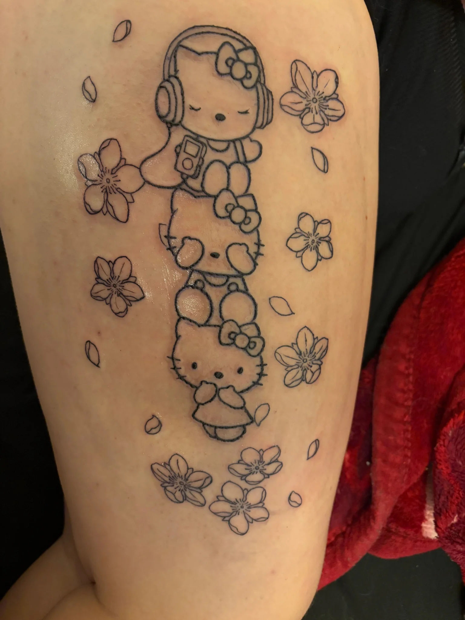 Fine line Hello Kitty stack with cherry blossoms on thigh