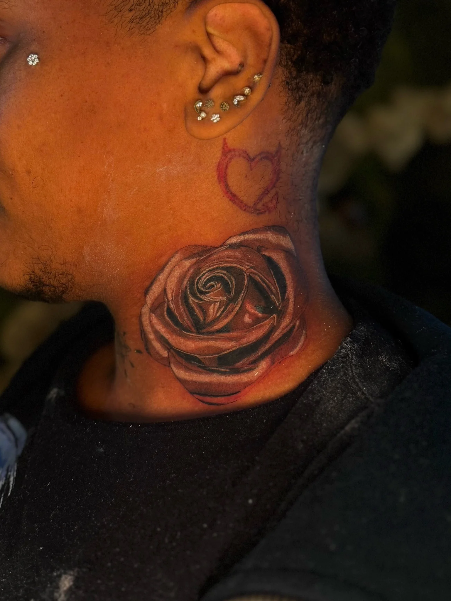 Black and grey realist rose tattoo on neck with small heart